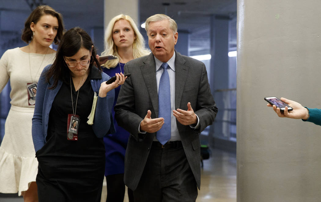 Sen. Lindsey Graham, R-S.C., right, answers reporters' questions, Friday, Jan. 24, 2020, on Cap ...
