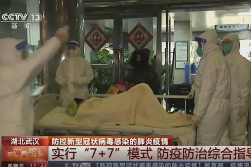 In this Thursday, Jan. 23, 2020, image from China's CCTV video, a patient is carried on a stret ...