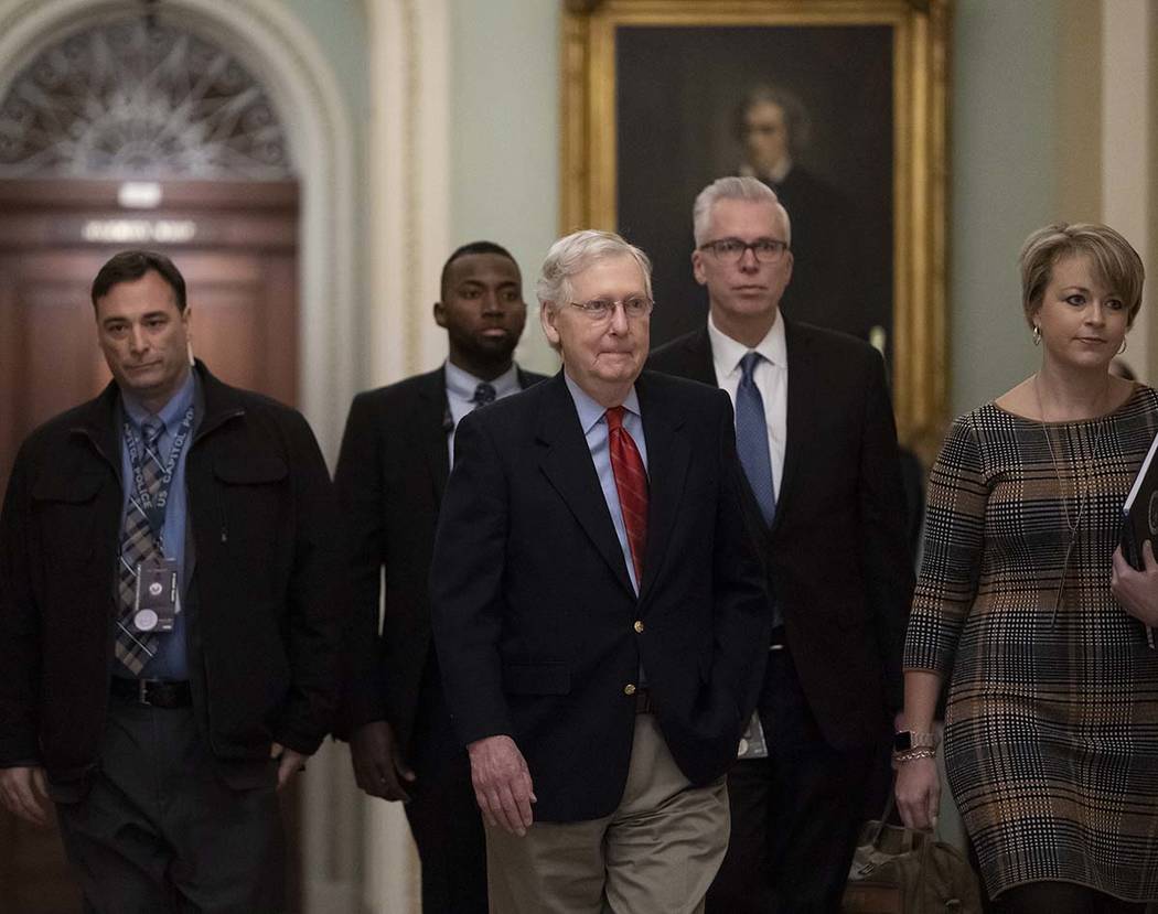 Senate Majority Leader Mitch McConnell, R-Ky., arrives at the chamber as work resumes in the im ...