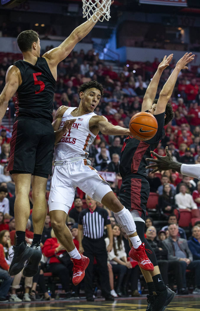 UNLV Rebels guard Marvin Coleman (31, center) gets off a pass between San Diego State Aztecs fo ...