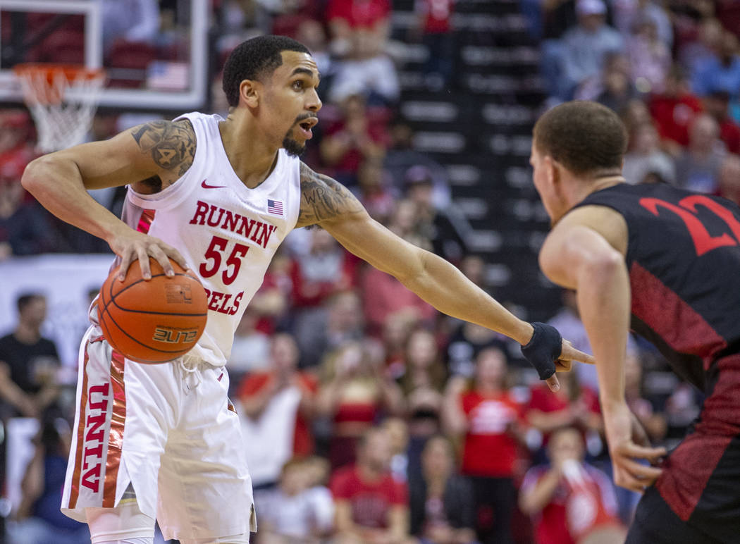 UNLV Rebels guard Elijah Mitrou-Long (55, left) signals to a teammate while guarded by San Dieg ...