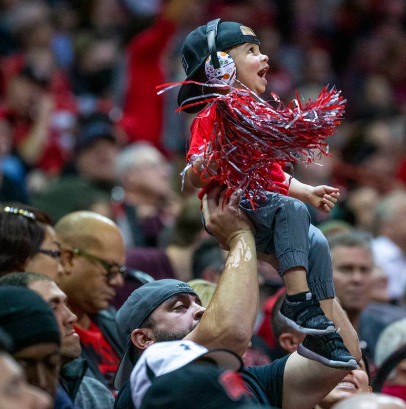 A young UNLV Rebels fan is hoisted up while cheering for the team versus the San Diego State Az ...