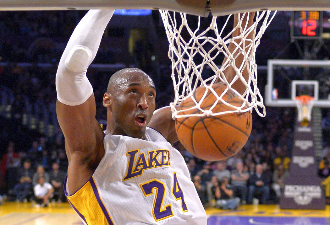 FILE - In this Jan. 4, 2015 file photo Los Angeles Lakers guard Kobe Bryant dunks during the fi ...