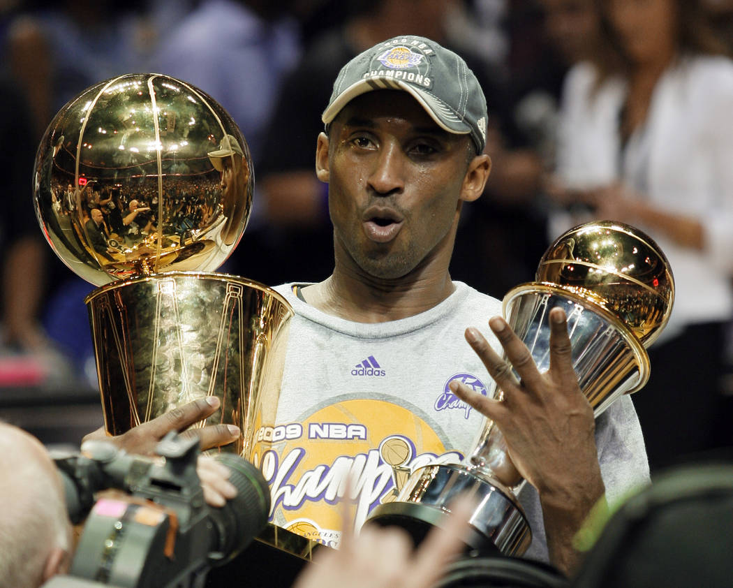 FILE - In this June 14, 2009 file photo Los Angeles Lakers' Kobe Bryant holds the Larry O'Brien ...