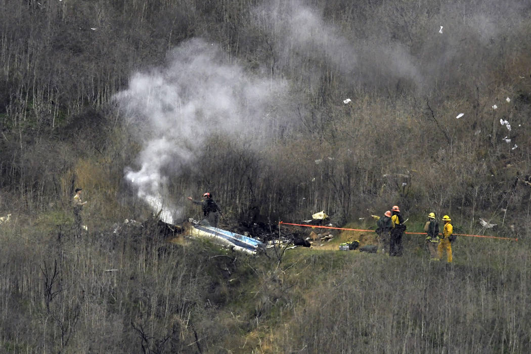 Firefighters work the scene of a helicopter crash Sunday, Jan. 26, 2020, in Calabasas, Calif. N ...