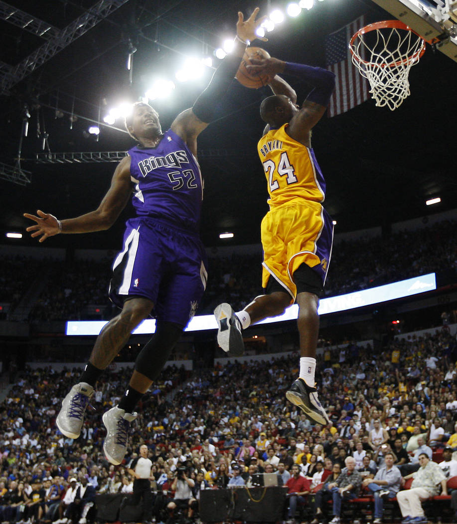 Kobe Bryant (24) of the Los Angeles Lakers goes in for a dunk past the Sacramento Kings' James ...