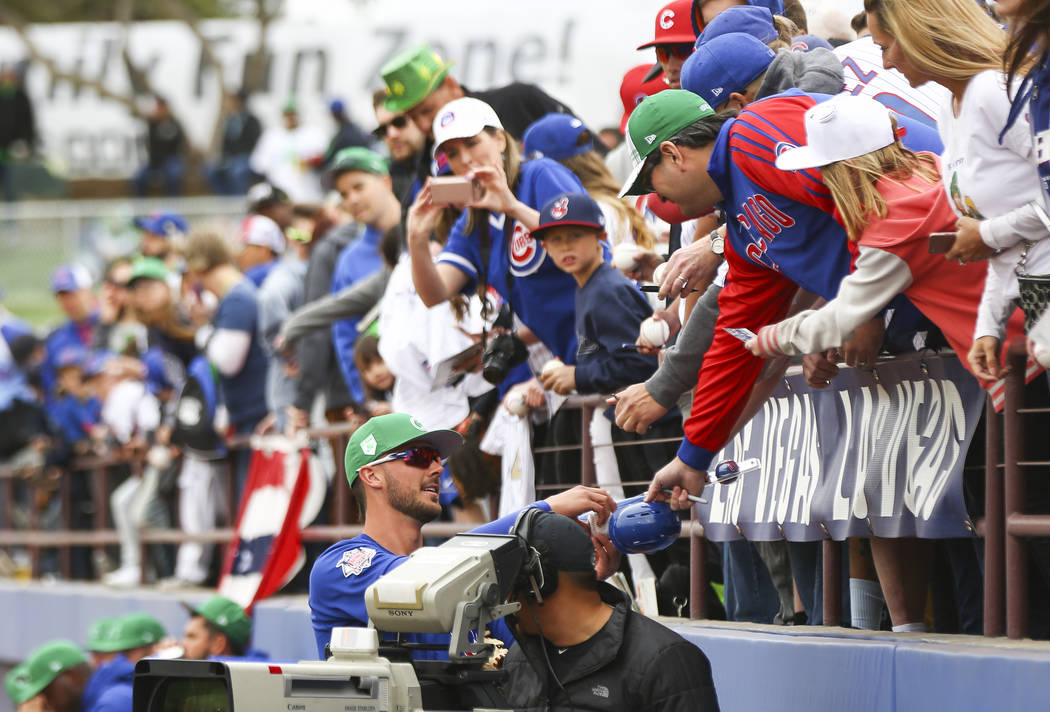 Chicago Cubs third baseman Kris Bryant autographs items for fans before playing the Cleveland I ...