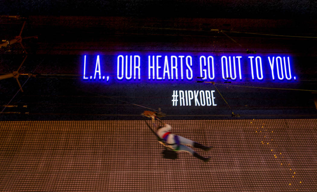 A SlotZilla Zipline rider moves past as the Fremont Street Experience offers sympathy to L.A. w ...