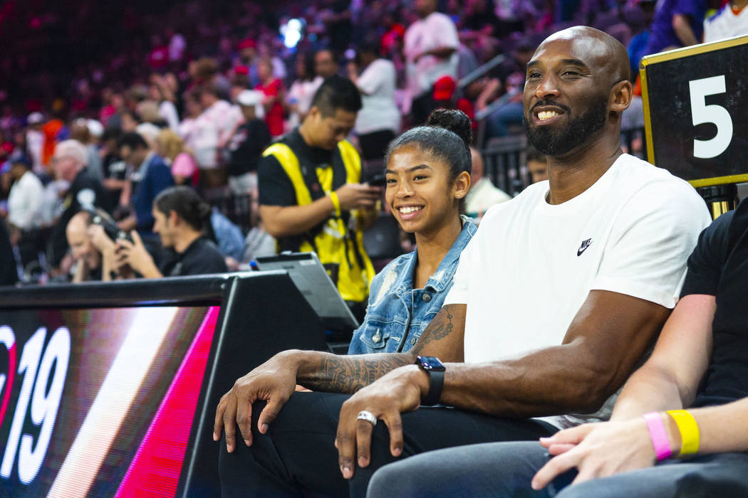 NBA legend Kobe Bryant sits with his daughter, Gianna, before the start of the WNBA All-Star Ga ...