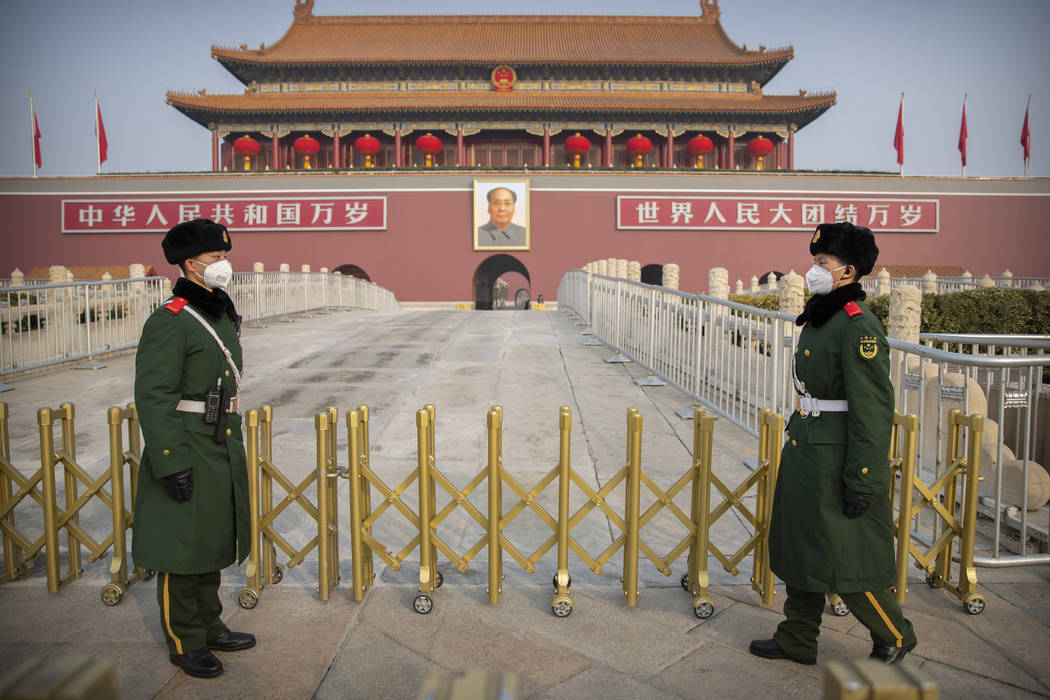 Paramilitary police wear face masks as they stand guard at Tiananmen Gate adjacent to Tiananmen ...