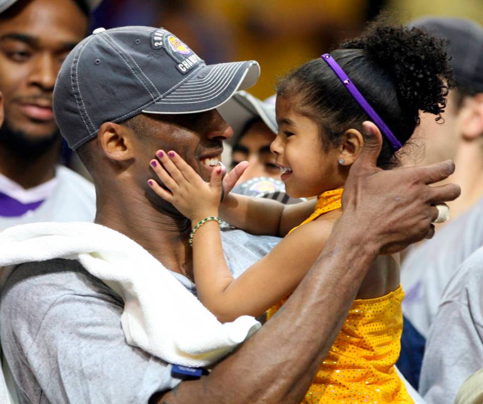 In this June 14, 2009, photo, Los Angles Lakers guard Kobe Bryant celebrates with his daughter ...