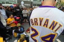 Fans mourn the loss of Kobe Bryant with makeshift memorials in front of La Live across from Sta ...