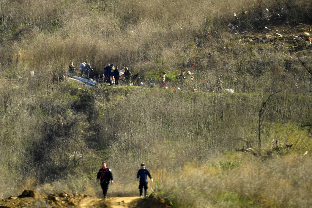 Investigators work the scene of a helicopter crash that killed former NBA basketball player Kob ...
