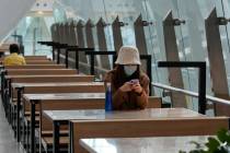 A woman wears protective face mask at the high speed train station in Hong Kong, Tuesday, Jan. ...