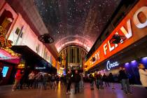 People watch the recently-upgraded Viva Vision screen at the Fremont Street Experience. A man l ...