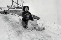 Two fun-loving residents take a trip down a snow-covered hill in Las Vegas, Jan. 31, 1979. (Las ...
