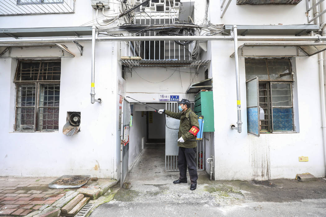 A government worker sprays disinfectant on a residential building in Wuhan in central China's H ...