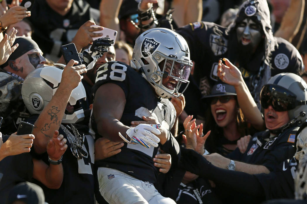 Oakland Raiders running back Josh Jacobs celebrates with fans after scoring against the Detroit ...