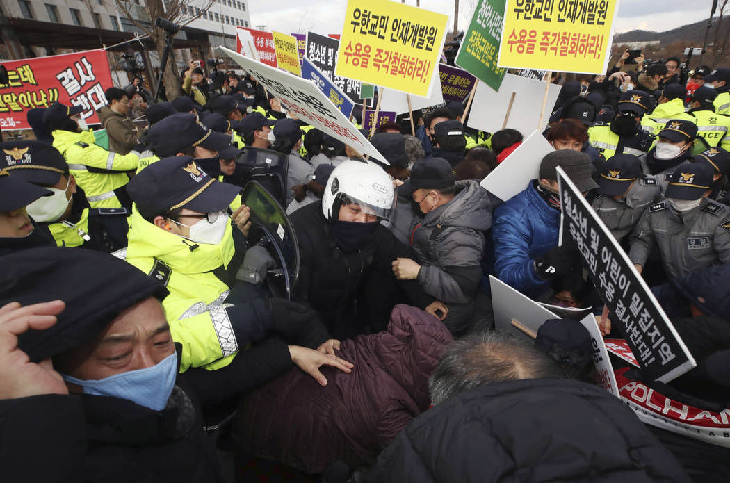 Residents scuffle with police officers during a rally to protest the government's decision to q ...