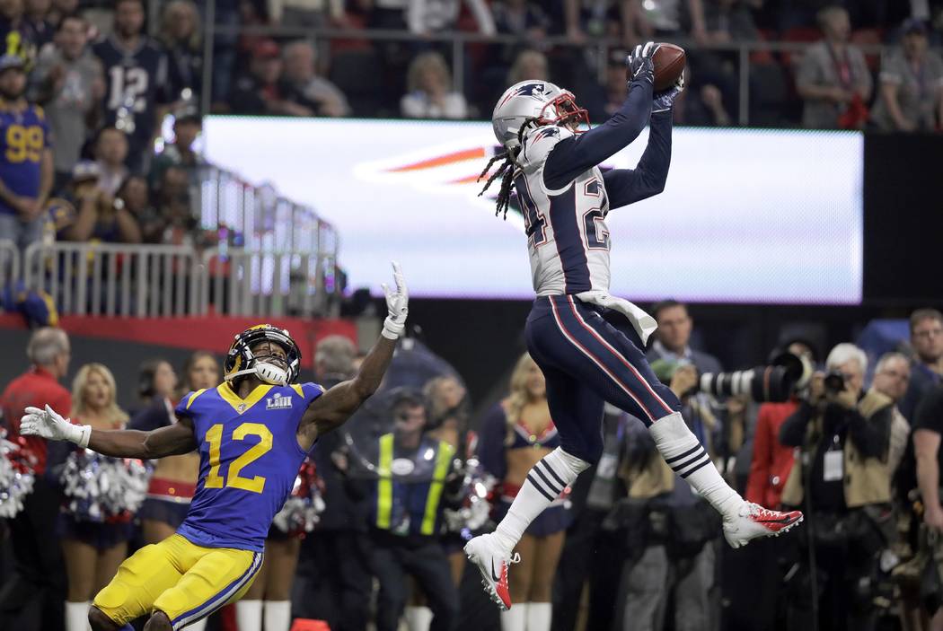 New England Patriots' Stephon Gilmore, right, intercepts a pass intended for Los Angeles Rams' ...