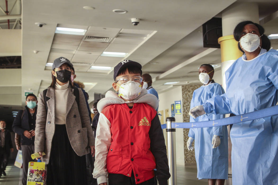 Passengers arriving from a China Southern Airlines flight from Changsha in China are screened f ...