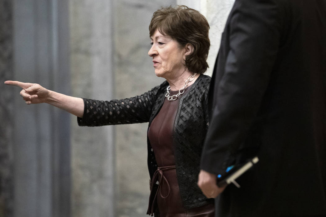 Sen. Susan Collins, R-Maine, points toward the elevator as she arrives, Wednesday, Jan. 29, 202 ...