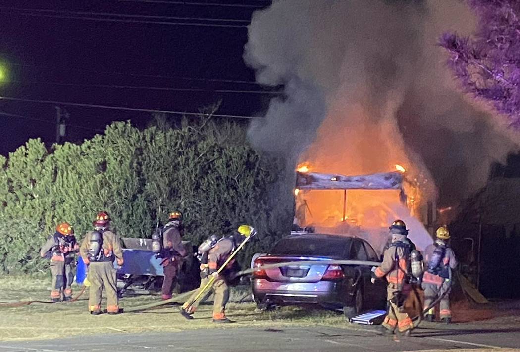 Firefighters work to extinguish a blaze in a recreational vehicle near West Bonanza Road and Ma ...