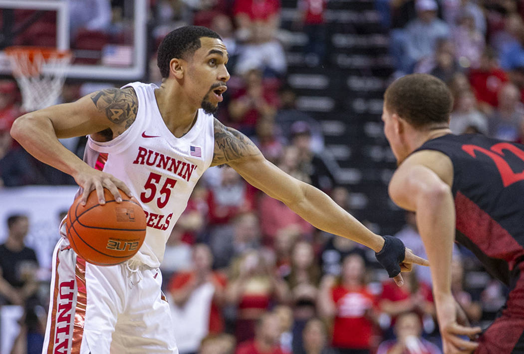 UNLV Rebels guard Elijah Mitrou-Long (55, left) signals to a teammate while guarded by San Dieg ...