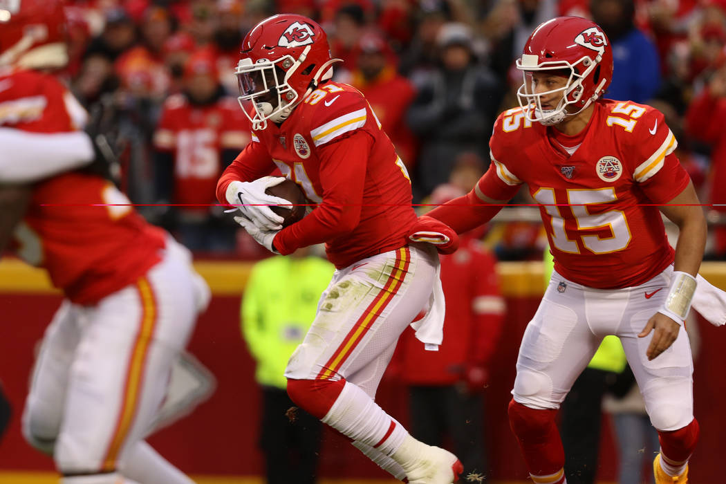 Kansas City Chiefs quarterback Patrick Mahomes (15) hands off the football to running back Darr ...