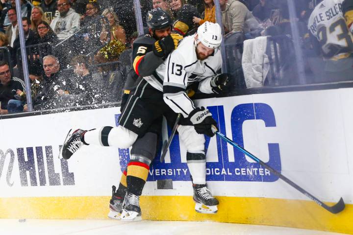 Golden Knights' Deryk Engelland (5) takes Los Angeles Kings' Kyle Clifford (13) to the boards d ...