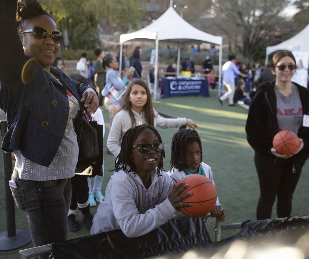 Lenita Austin, left, and her sons Ender Austin, 8, center, and Ethan Austin, 5, right, play a m ...