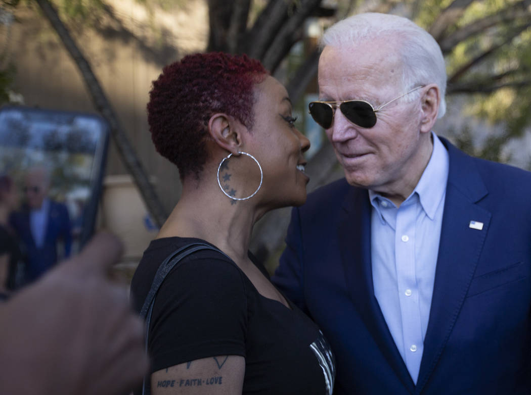 Jasmin Johnston speaks into presidential candidate Joe Biden's ear before posing for a photo wi ...