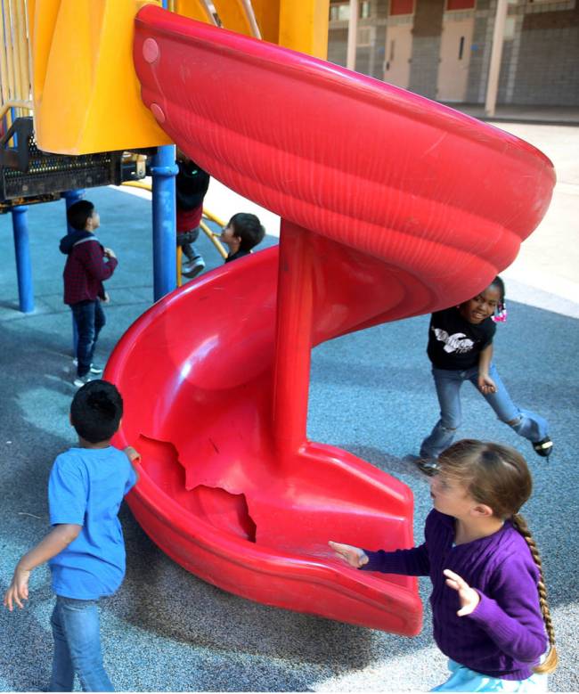 Students run around a broken slide in the playground at Helen Smith Elementary School in Las Ve ...