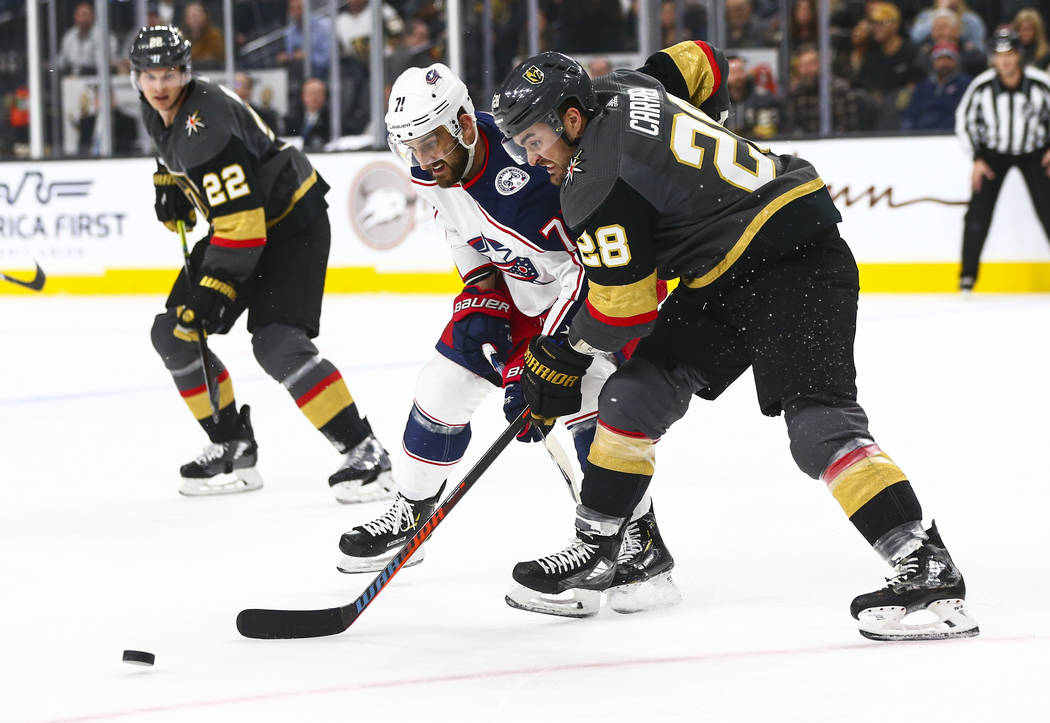 Golden Knights' William Carrier (28) battles for the puck against Columbus Blue Jackets' Nick F ...
