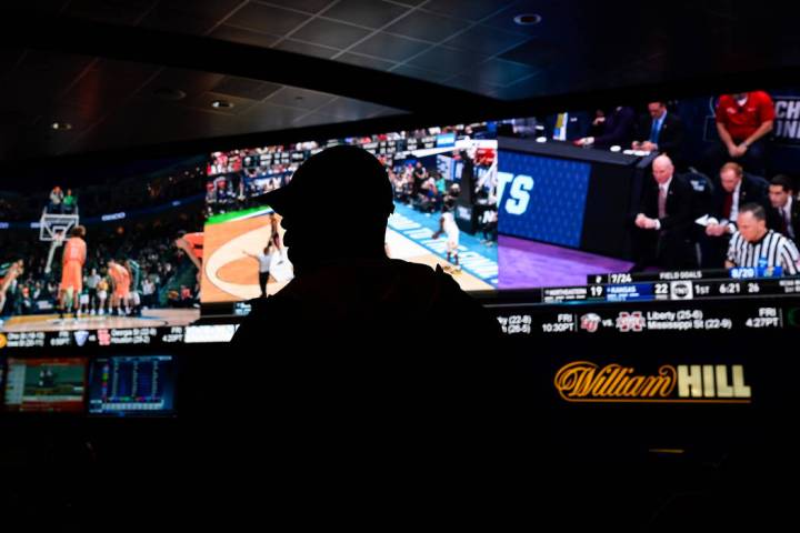 A fan watches the first round of the NCAA men's college basketball tournament at the newly open ...