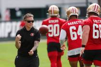 San Francisco 49ers offensive assistant coach Katie Sowers, left, tosses a ball to players duri ...
