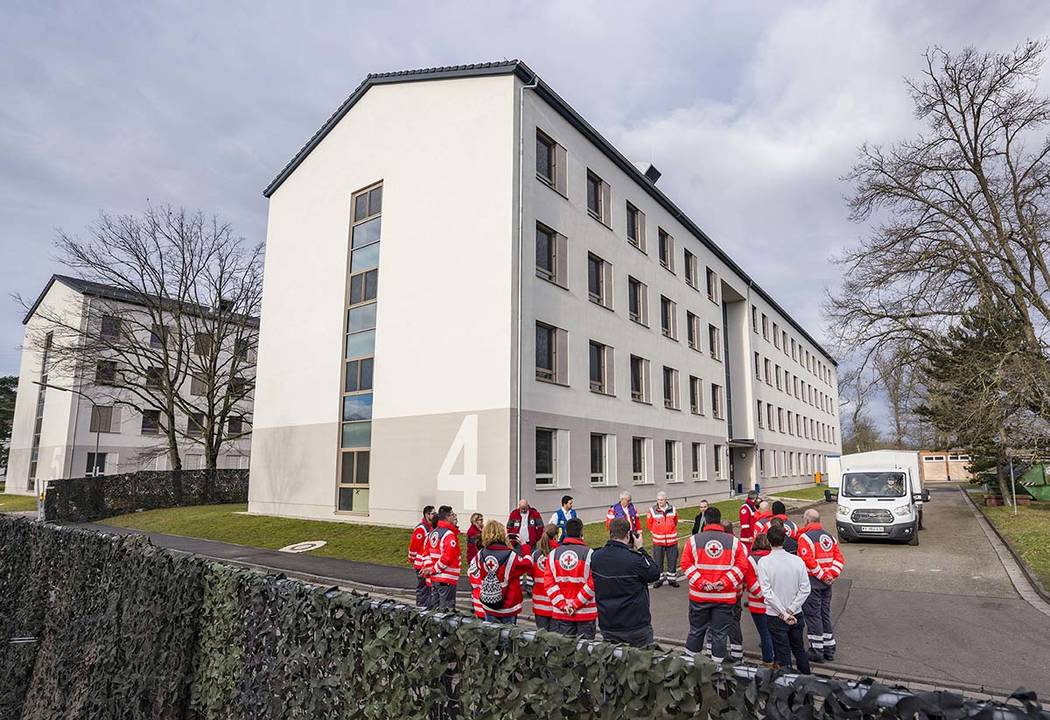 Red Cross employees stand in front of the building on the grounds of the barracks Südpfalz ...