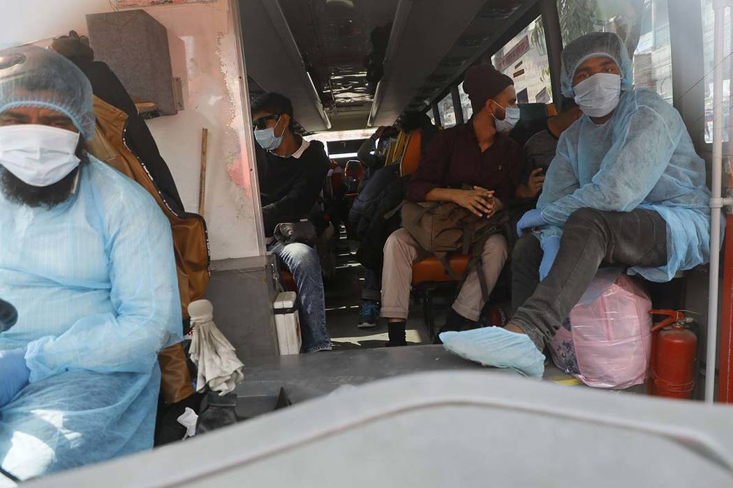 Bangladesh citizens, who were brought back in a special aircraft from Wuhan, ride a bus at the ...