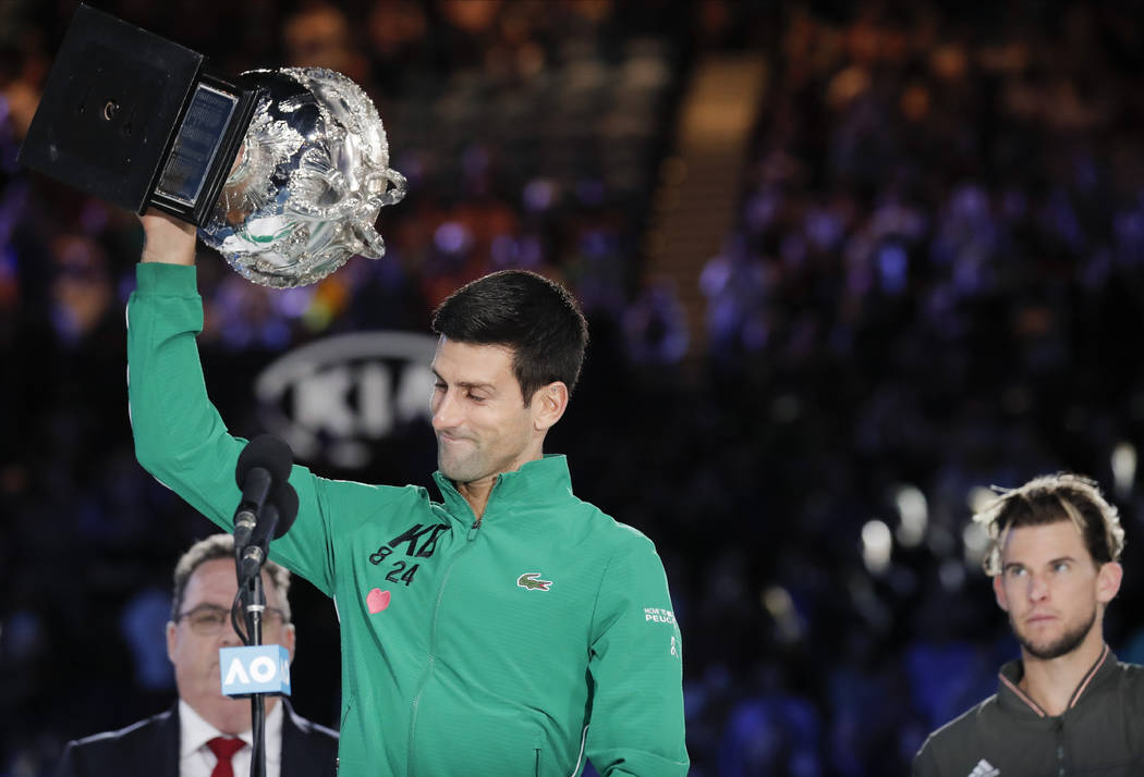 Serbia's Novak Djokovic, left, holds the Norman Brookes Challenge Cup after defeating Austria's ...