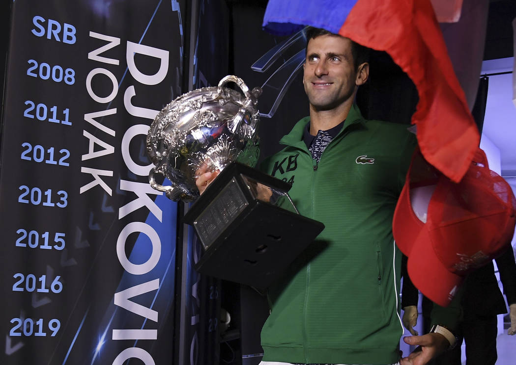 Serbia's Novak Djokovic carries the Norman Brookes Challenge Cup onto Margaret Court Arena to c ...