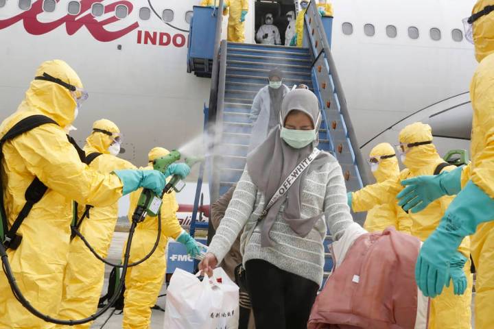 In this photo released by Indonesian Foreign Ministry, Indonesian people who arrived from Wuhan ...