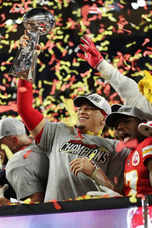 Kansas City Chiefs quarterback Patrick Mahomes (15) holds up the Vince Lombardi Trophy after th ...