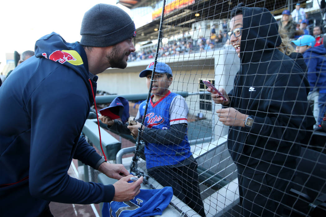 Chicago Cubs player Kris Bryant signs an autograph for Marco Valdovinos, right, 15, and Steve M ...