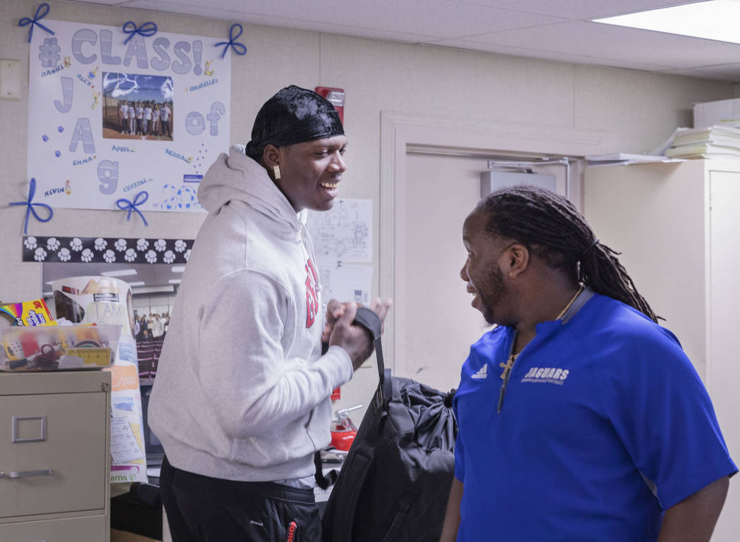 Desert Pines High School's wide receiver senior Darnell Washington, left, and assistant coach a ...