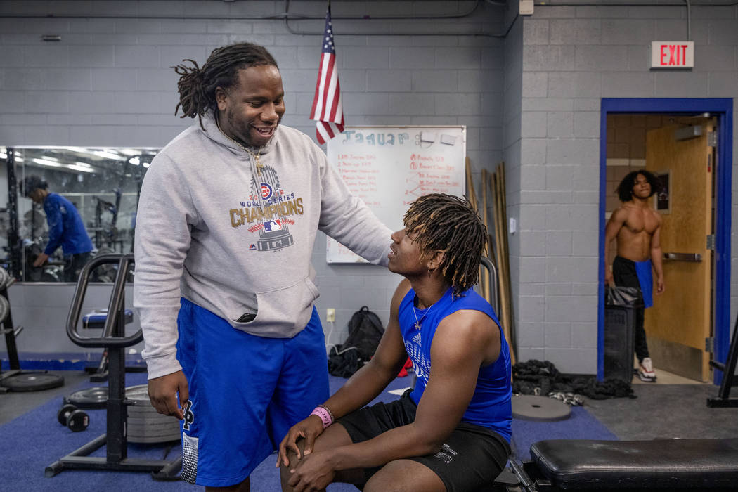 Desert Pines High School assistant football coach David Hill, left, speaks with junior running ...