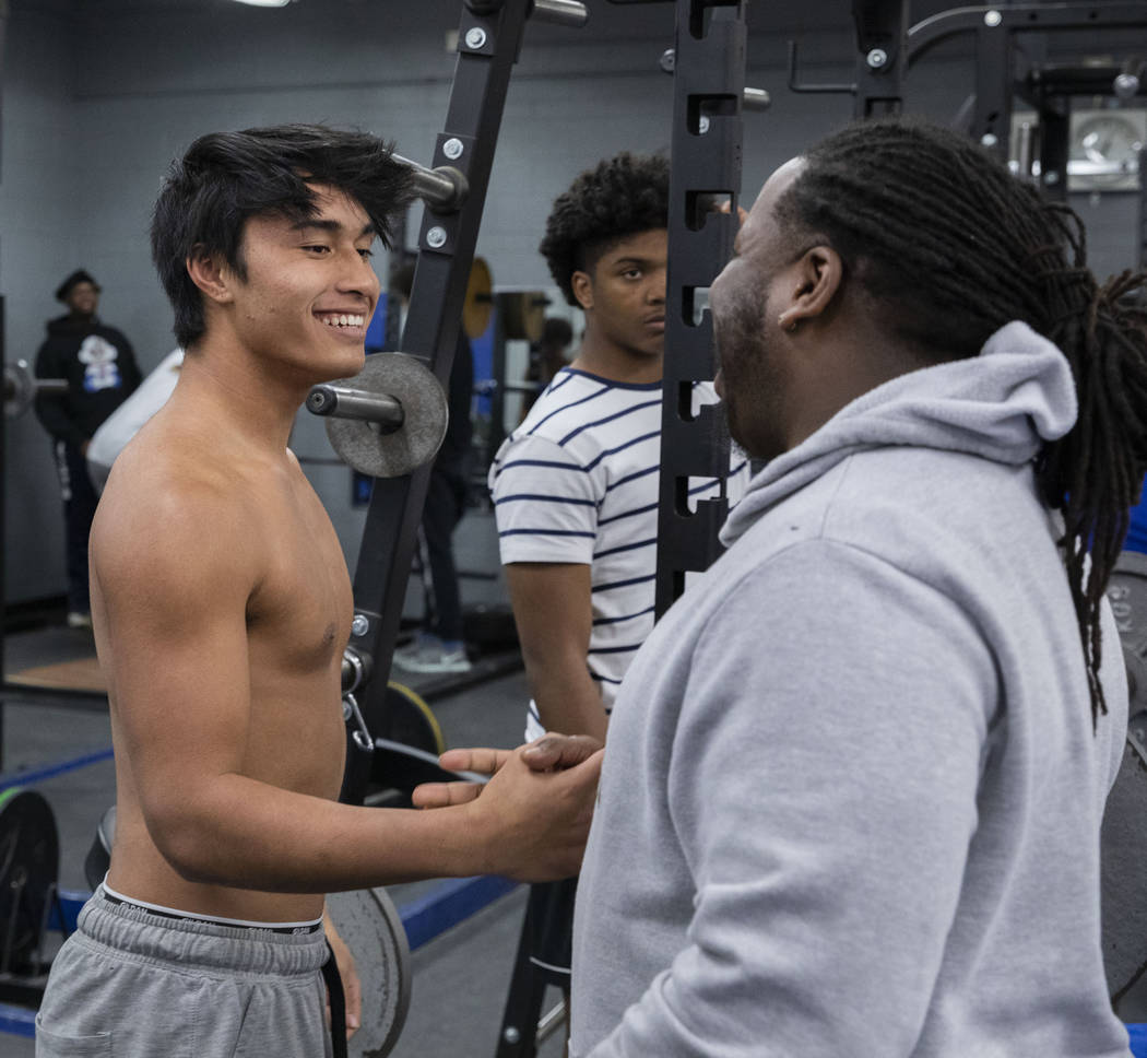 Desert Pines High School sophomore, receiver Jett Solomon, left, is congratulated by assistant ...