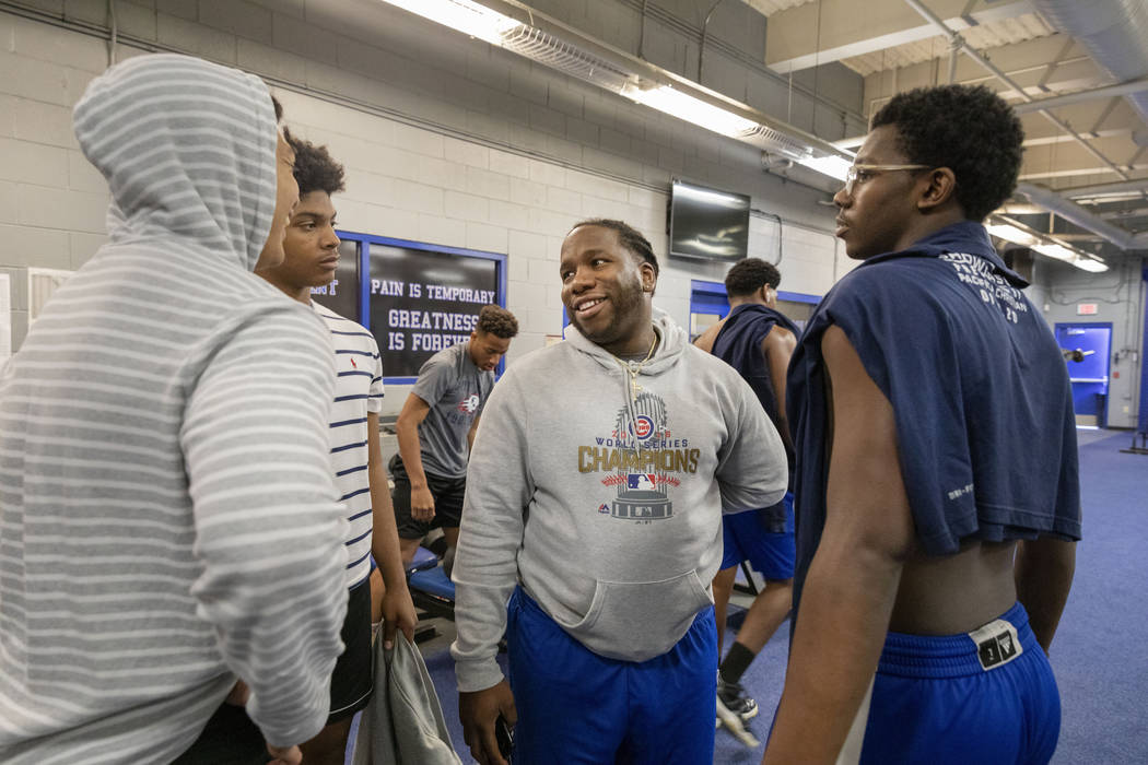 Desert Pines High School's assistant football coach David Hill, center, speaks with his players ...