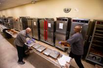Bob Ayouba, left, and Sarif El-Amin, of Three Square food bank, package fried chicken and other ...