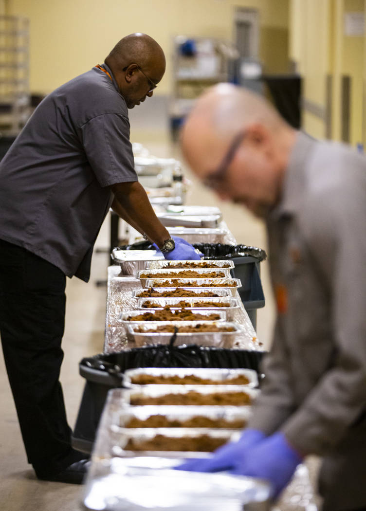 Sarif El-Amin, left, and Bob Ayouba, of Three Square food bank, package beef brisket and other ...