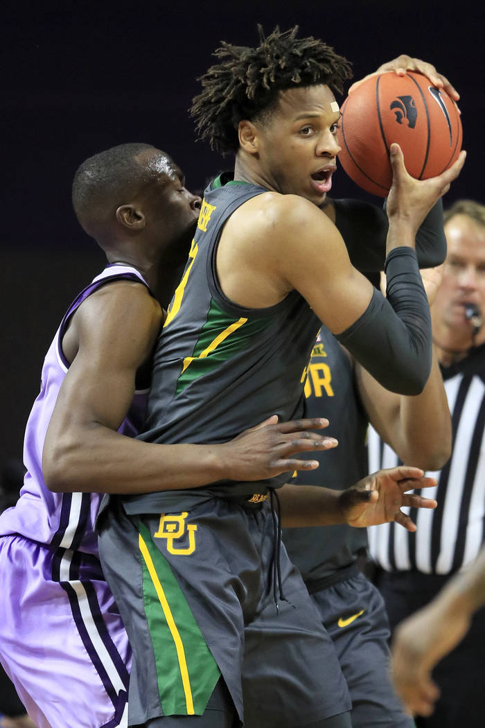 Baylor forward Freddie Gillespie, right, is covered by Kansas State forward Makol Mawien, left, ...